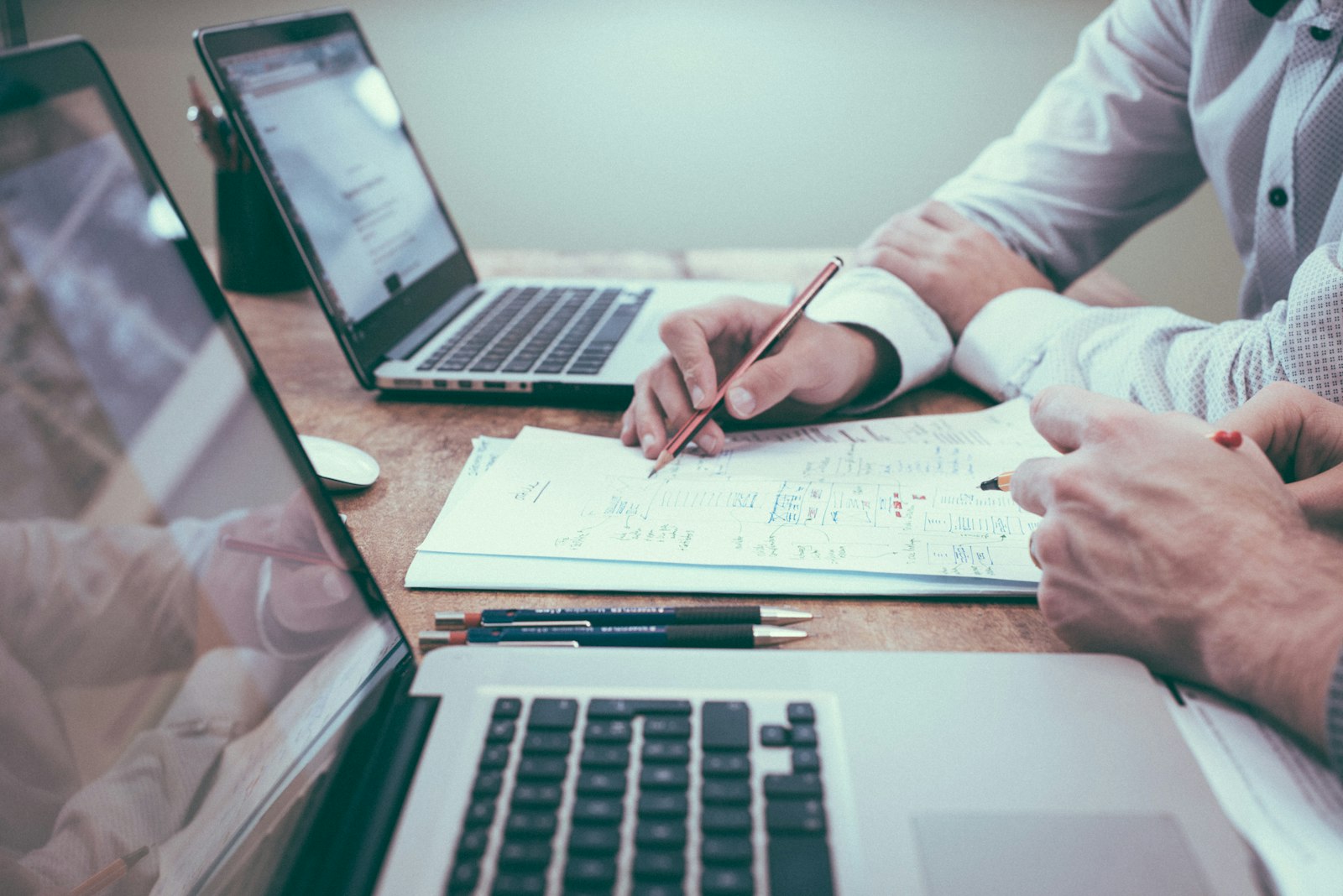 Two partners reviewing strategy sketches on a wooden desk